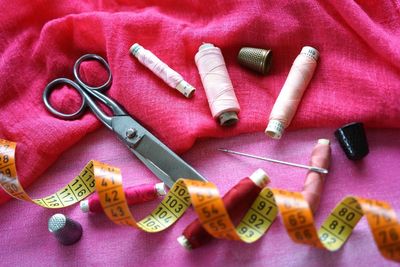 High angle view of sewing items on pink fabrics