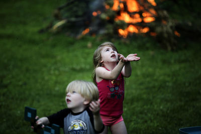 Two children playing by bonfire