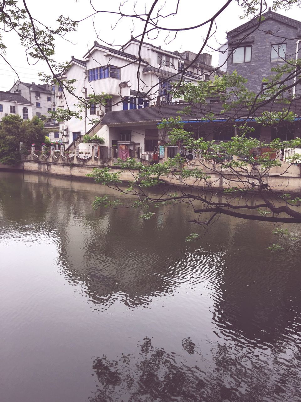 building exterior, architecture, built structure, water, reflection, waterfront, canal, tree, city, residential building, river, residential structure, house, building, rippled, lake, day, outdoors, sky, no people