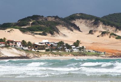 Scenic view of beach by mountain against sky