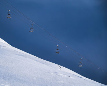 Low angle view of overhead cable car against sky