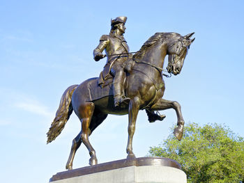 Low angle view of statue against blue sky