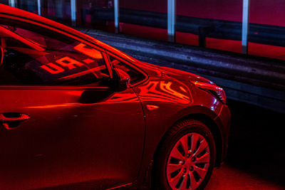 Red car parked on street at night