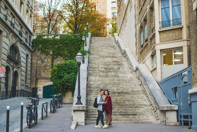 People walking on street amidst buildings in city