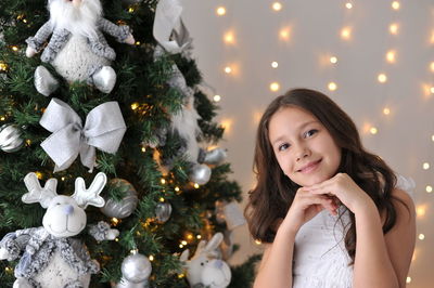 Portrait of young woman decorating christmas tree