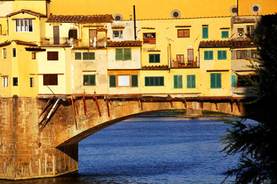 Ponte vecchio over arno river on sunny day