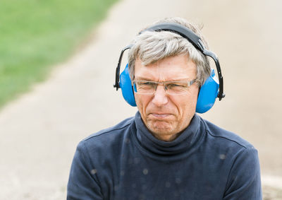 Portrait of man wearing headphones outdoors