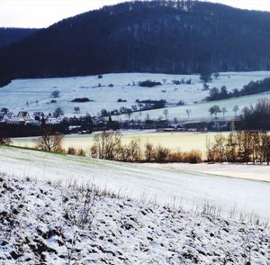 Scenic view of snow covered field against sky