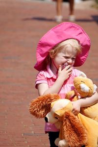 Girl carrying stuffed toys on footpath