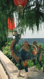 Bird perching on tree against sky