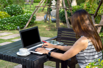 Side view of woman using mobile phone