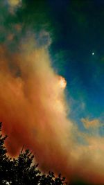 Low angle view of silhouette trees against dramatic sky