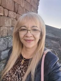 Portrait of smiling woman against wall