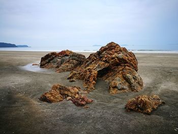 Rocks on beach against sky