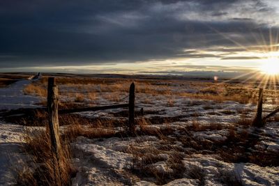 Corner of pasture fence line at sunset