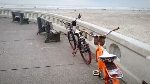 Bicycle parked on street by sea in city