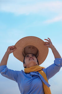 Portrait of boy wearing hat against blue sky