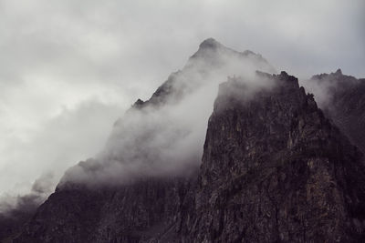 Low angle view of rocky mountains against sky