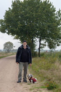 Senior on a dogwalk on a field road