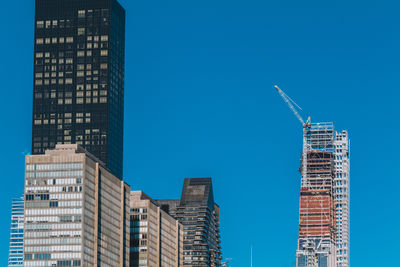 Building under construction with crane on a building in new york city on a blue sky background