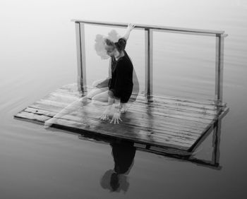 Double exposure of woman on floating platform in lake