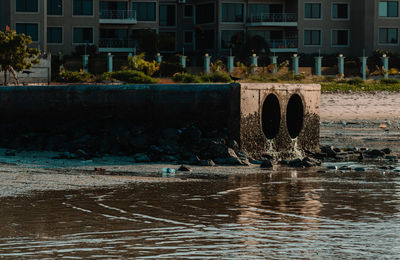 Arch bridge over river against buildings in city