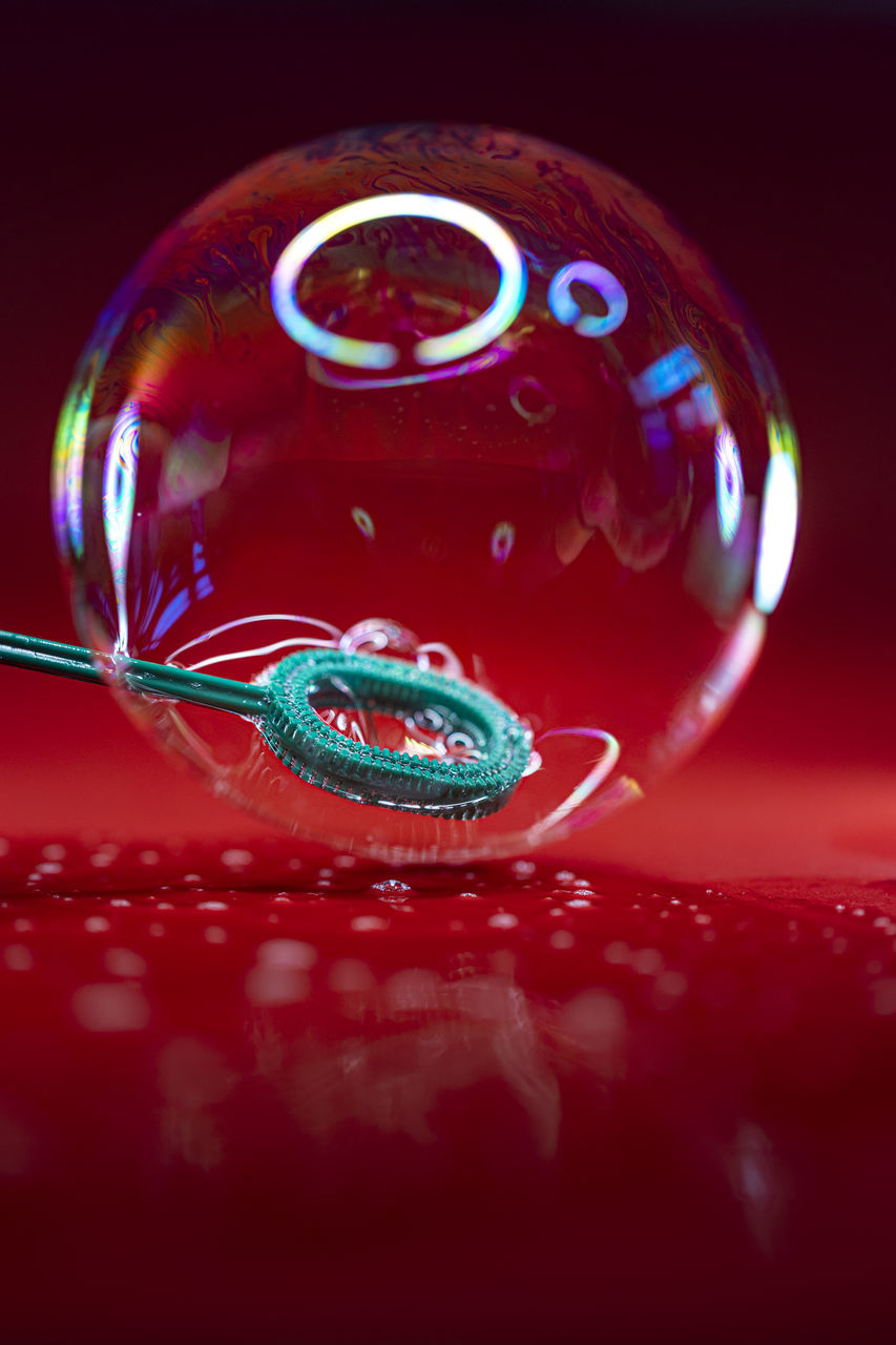 red, sphere, bubble, glass, indoors, no people, studio shot, ball, crystal ball, reflection, close-up, macro photography, shape, single object, shiny, drop, colored background, nature