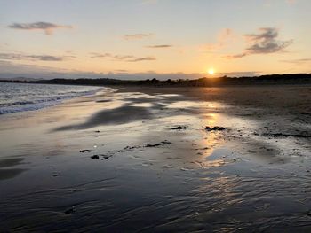 Scenic view of beach against sky during sunset