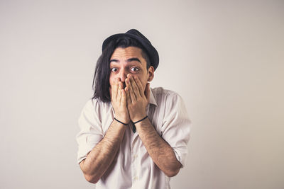 Portrait of young man standing against white background