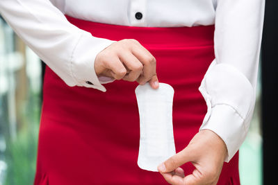 Close-up of hand holding red standing against white background