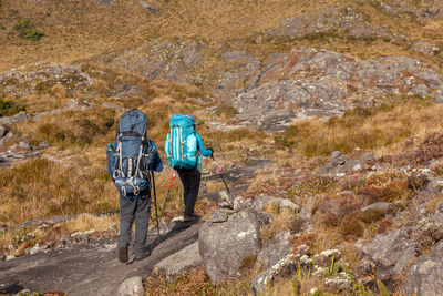 Rear view of men standing on rock