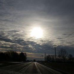 Railroad tracks against cloudy sky