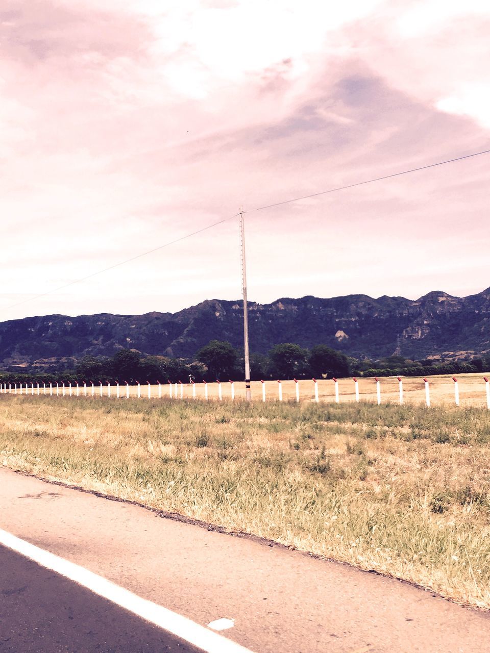 mountain, landscape, sky, tranquil scene, tranquility, mountain range, electricity pylon, field, power line, scenics, road, nature, rural scene, beauty in nature, non-urban scene, electricity, cloud - sky, grass, countryside, power supply