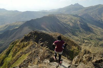 Woman standing on mountain against sky