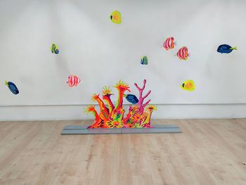 Various flowers on table against wall