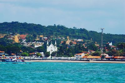 Houses by sea against blue sky