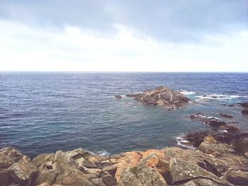 Scenic view of sea against cloudy sky