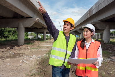 Happy friends standing at construction site