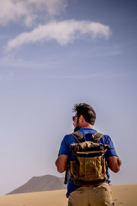 Rear view of man standing against clear sky