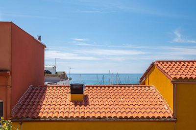 High section of building by sea against sky