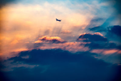 Low angle view of silhouette airplane flying in sky