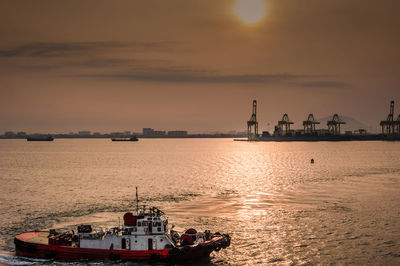 Silhouette of boats at harbor during sunset