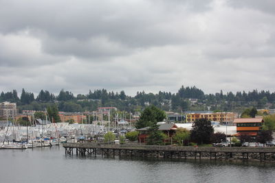 Scenic view of river by buildings against sky