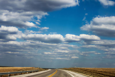 Road passing through landscape against sky