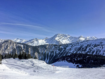 Scenic view of snowcapped mountains against blue sky