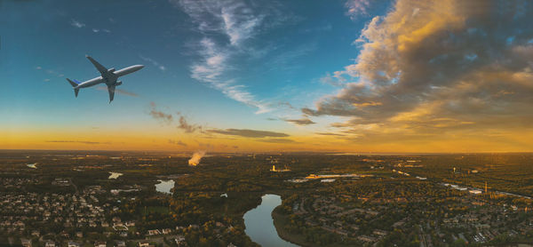 Airplane flying over cityscape against sky