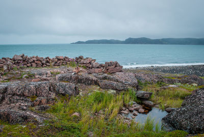 Rocks by sea against sky