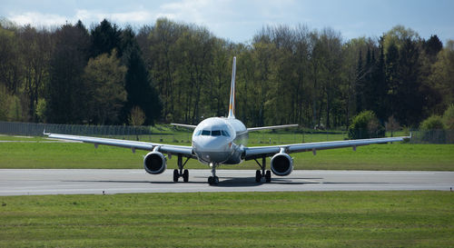 View of airplane at airport runway against sky