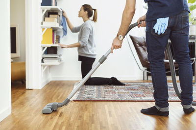 Low section of men standing on hardwood floor at home