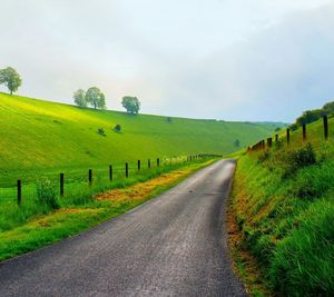 Country road passing through grassy field